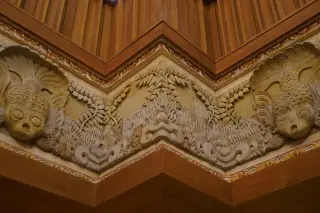 Illustration: Intricate carved stone and wood reliefs forming an architectural interior corner.