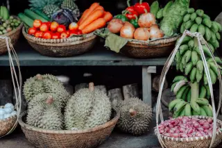 Illustration: Fresh fruits and vegetables displayed in woven baskets at an outdoor market stall.