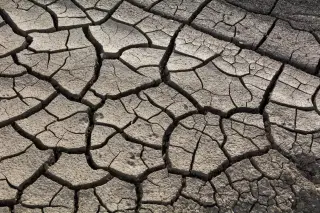 Illustration: A close-up view of severely cracked, dry arid soil.