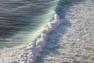 Illustration: A turquoise ocean wave breaking with white sea foam across the water surface.