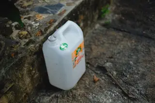 Illustration: A white plastic jug sits on a weathered concrete step.