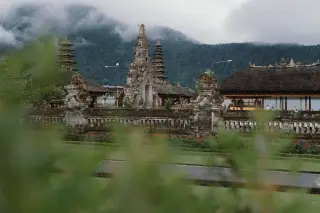 Illustration: A Balinese temple complex with tiered shrines set against a misty mountain.