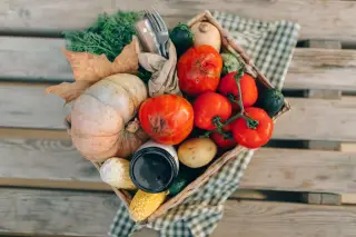 Illustration: A top-down view of a basket filled with fresh vegetables on a wooden surface.