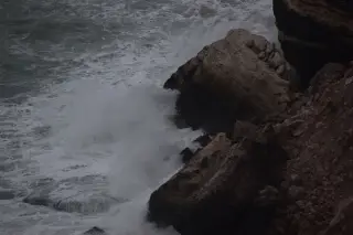 Illustration: Rough ocean waves crashing against a dark rocky cliff.